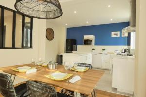a dining room with a wooden table and a kitchen at Lambraz in Brest
