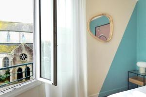 a bedroom with a window and a mirror at Lambraz in Brest