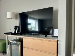 a large flat screen tv sitting on top of a dresser at The Harbor Inn in Grand Marais
