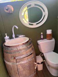 a bathroom with a barrel sink and a mirror at Lago Amor del Valle Glamping Súper in San Antonio de las Minas +27 photos