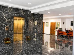 an office lobby with black marble walls and a desk at Lungolago Apartment Ohrid in Ohrid