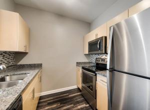 a kitchen with a stainless steel refrigerator and a sink at King Aqua Suite Walkable Legacy West King Bed, Pool & Gym in Plano