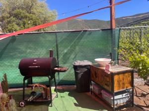 a grill and a table next to a green screen at Lago Amor del Valle Glamping Súper in San Antonio de las Minas
