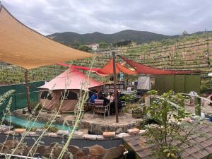 a group of people sitting under umbrellas next to a pool at Lago Amor del Valle Glamping Súper in San Antonio de las Minas