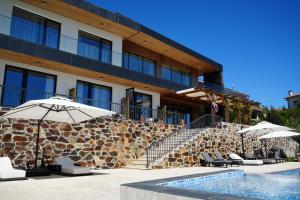 a hotel with umbrellas and chairs next to a pool at Quinta de Raj - Your Douro Valley Retreat in Peso da Régua