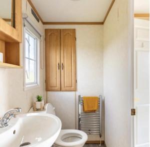 a bathroom with a white toilet and a sink at Attymchugh Lodge in Corlee +50 photos