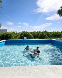 three people are playing in a swimming pool at Villa Los Naranjos in Carcaixent
