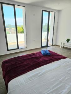 a large bed in a room with large windows at Villa Los Naranjos in Carcaixent