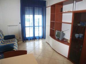 - un salon avec un canapé et une télévision dans l'établissement Zancan Appartament, à Grado