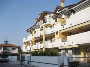 un grand bâtiment blanc et jaune dans une rue dans l'établissement Zancan Appartament, à Grado