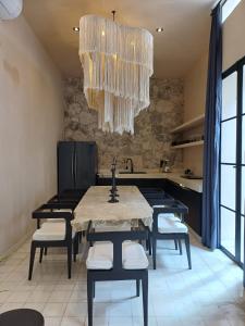 a kitchen with a table and chairs and a chandelier at Casa Josefina in Hunucmá