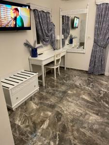 a room with a desk and a tv and a mirror at Dionisia Apartments in Kefalos
