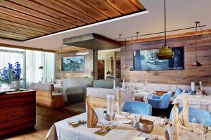 un ristorante con tavoli bianchi e sedie blu di Hotel Prokulus a Naturno