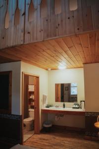 ein Badezimmer mit Waschbecken, Toilette und Spiegel in der Unterkunft Lenroot Lodge in Seeley