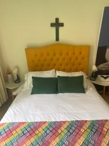 a large bed with a cross on the wall at Apartamento Turístico Frailejones in Duitama