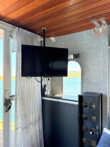 a flat screen tv hanging from a ceiling in a kitchen at House Boat in Capitólio
