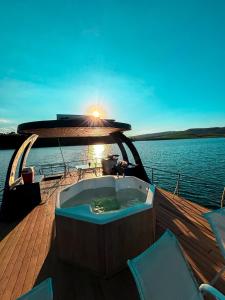 a hot tub on the deck of a boat on the water at House Boat in Capitólio