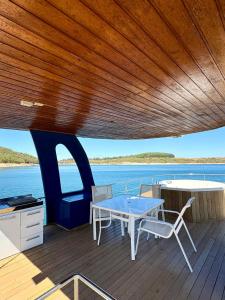 a wooden deck with a table and chairs on a boat at House Boat in Capitólio