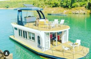 a boat with a deck on the water at House Boat in Capitólio +2 photos