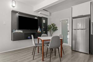 a dining room with a table and chairs and a tv at Balandras Beach Stay 1 Beach & Pool Access in Dorado