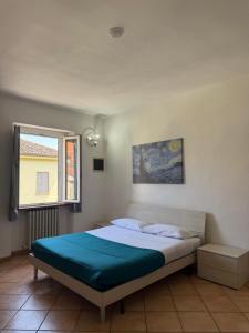 a bedroom with a large bed with a window at Spazioso appartamento 2 in Tortona
