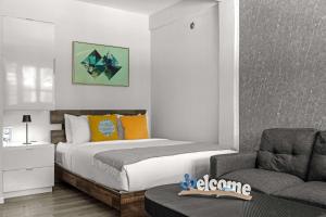a bedroom with a bed and a couch and a chair at Balandras Beach Stay 3 Beach & Pool Access in Dorado