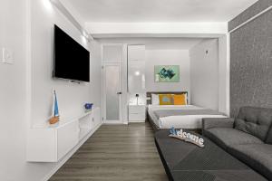 a room with a bed and a couch and a tv at Balandras Beach Stay 3 Beach & Pool Access in Dorado