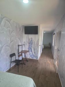 a bedroom with a wall with a tv on it at Harvestmoon Boutique Hotel in Las Piedras
