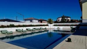 a swimming pool with lounge chairs next to a building at Hotel Arthur in Solignano Nuovo