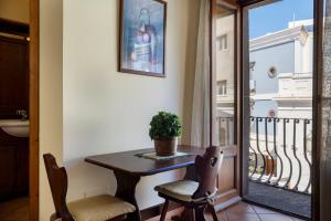 a table and two chairs in a room with a balcony at Case Vacanze Albamarina in Lipari