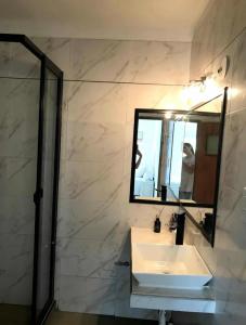 a bathroom with a sink and a mirror at Hospedaje Las Moreras-Vaqueros in Vaqueros +5 photos