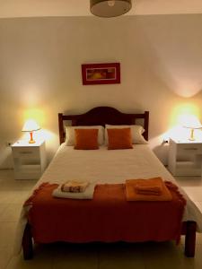 a bedroom with a large bed with two lamps at Hospedaje Las Moreras-Vaqueros in Vaqueros