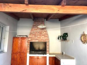 a living room with a fireplace and a brick wall at Hospedaje Las Moreras-Vaqueros in Vaqueros