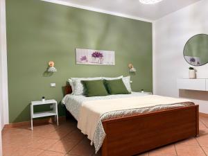 a bedroom with a bed and a green wall at Casa Rina in Piano Conte