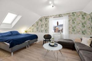 a bedroom with a bed and a couch and a table at Casa Formentera in Molde