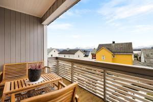 a balcony with a wooden bench and a vase of flowers at Casa Formentera in Molde