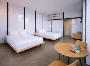 a hotel room with two beds and a table at Encuentro Guadalupe in Valle de Guadalupe