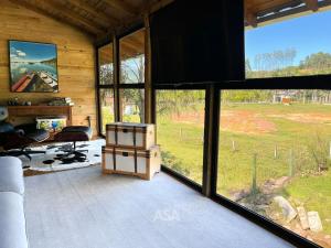 a living room with large windows in a house at Luxury Chalet Retreat with Jacuzzi & Fireplace in Itajaí