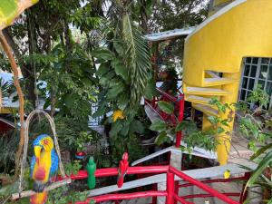 a toy house with birds on a red fence at Maison Tulum in Tulum