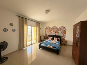 a bedroom with a bed and a large window at Anta's House Sipres - Chambre calme et confortable in Dakar