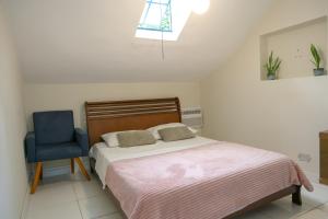 a bedroom with a bed and a blue chair at Hostel Castell Di Madre in Santos