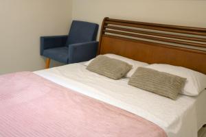 a bedroom with a bed and a blue chair at Hostel Castell Di Madre in Santos +47 photos
