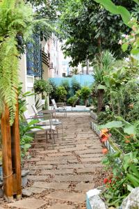 a stone walkway in a garden with chairs and plants at Hostel Castell Di Madre in Santos