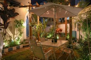 a table with an umbrella in a garden at night at Hostel Castell Di Madre in Santos