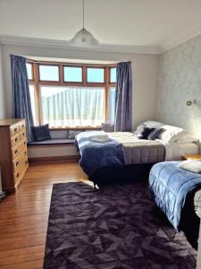 a bedroom with two beds and a window at Cosy On Till in Oamaru