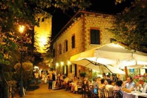 a group of people sitting at tables outside a building at Osteria Belvedere in San Leo