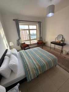 a bedroom with a large bed and a window at شاطئ المرجان in King Abdullah Economic City
