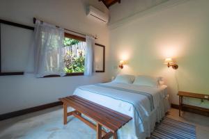 a white bedroom with a bed and a window at O Sitio - Ilha Grande in Abraão