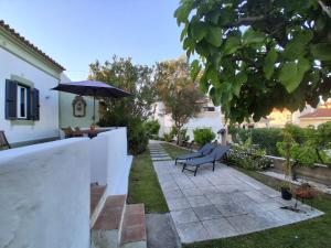 a patio with a bench and an umbrella at Monte da ti Luzia in Faro