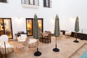 a room with tables and chairs and umbrellas at Rural VillaReyes in Cabeza la Vaca